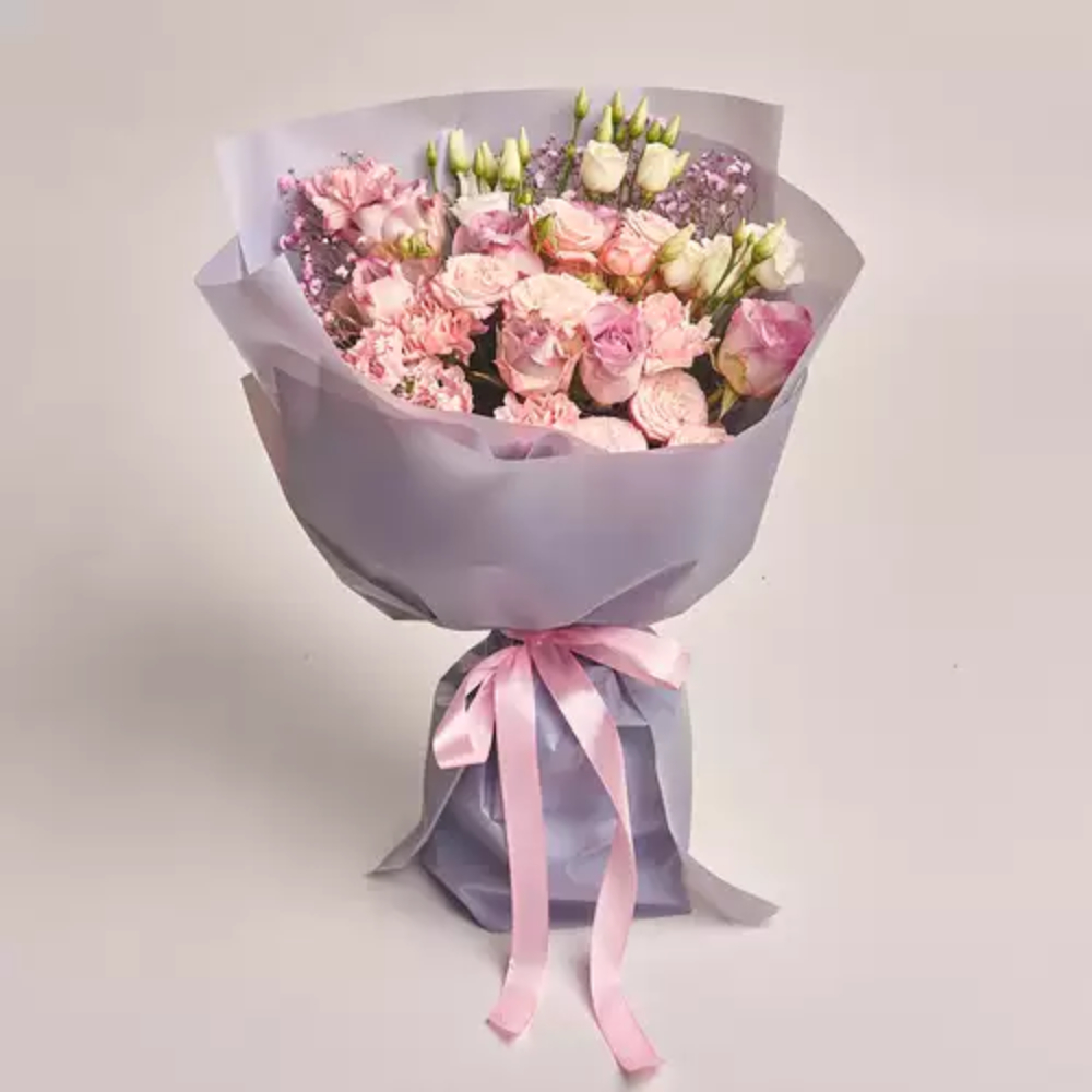 Premium mixed flower bouquet with pink roses, carnations, and white buds wrapped in grey paper with a pink ribbon, elegant floral gift by Favish Blooms Dubai