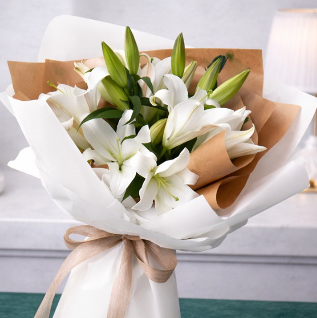 Elegant white lily bouquet wrapped in soft white and brown paper