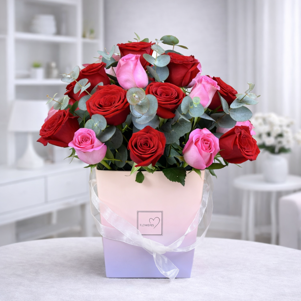 Elegant red and pink roses in pastel gift box arrangement