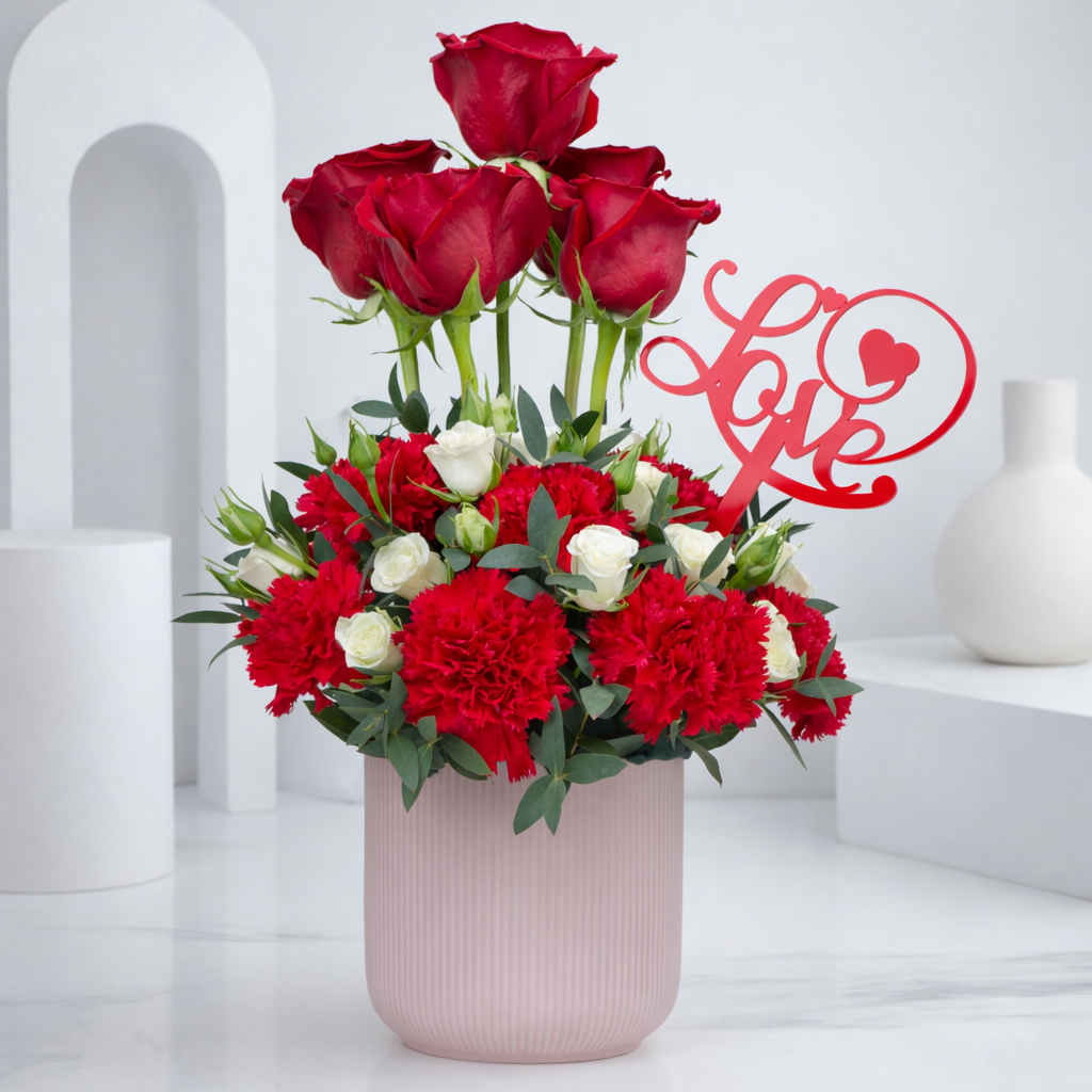 Romantic red and white flower arrangement with love topper in pink pot