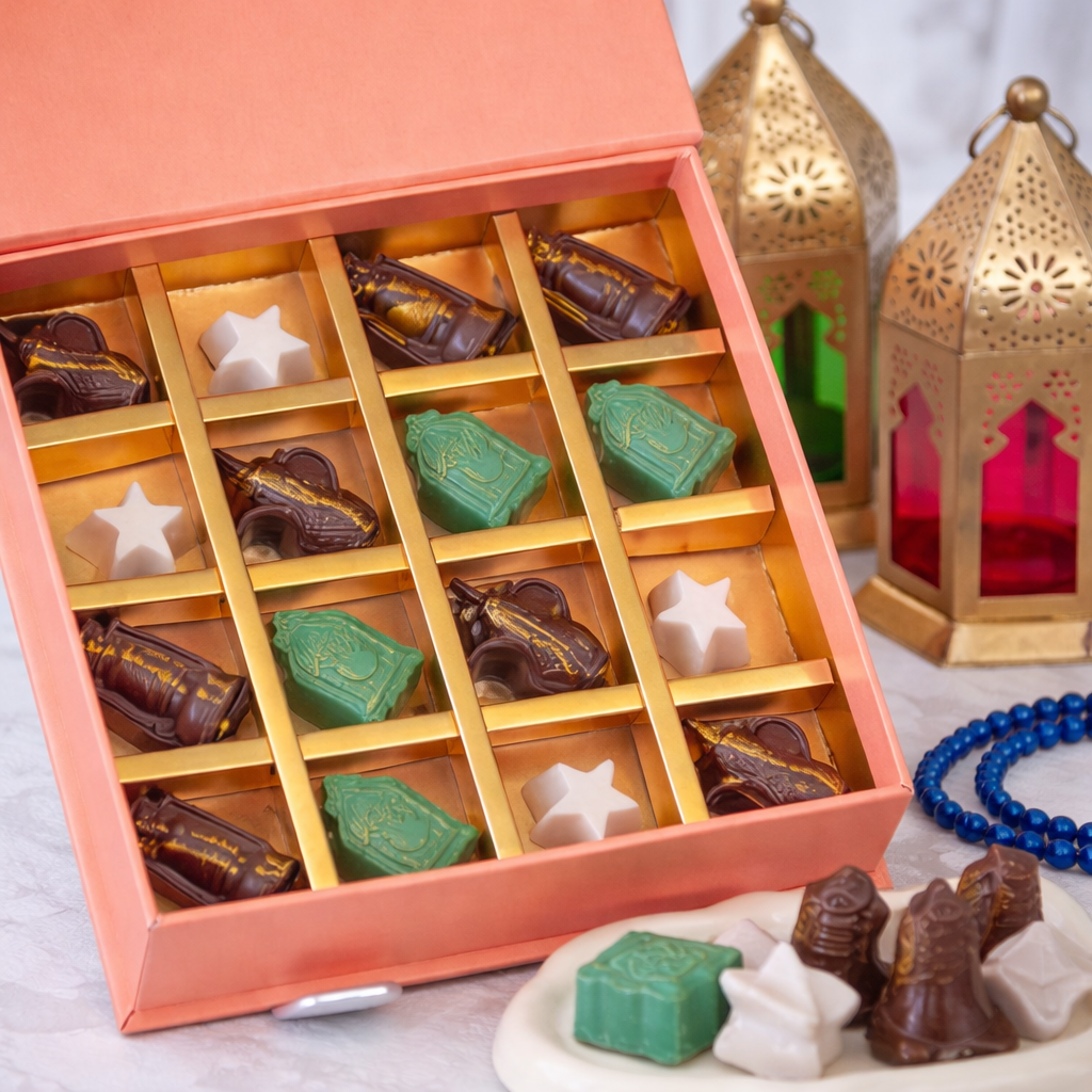 Pink gift box of Ramadan-themed chocolates shaped as mosques, stars, and lanterns, styled with gold Moorish lanterns and crescent fairy lights.