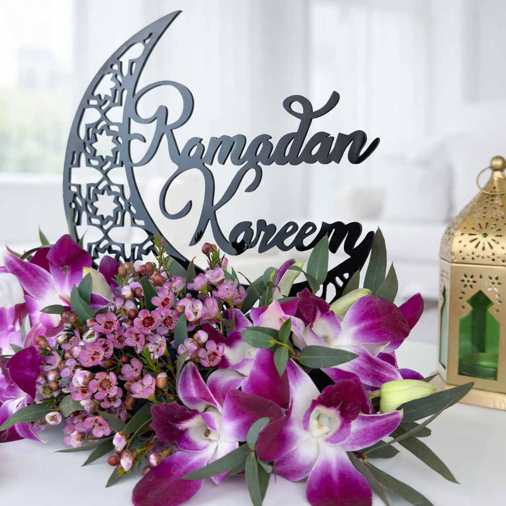 Close-up Ramadan Kareem orchid arrangement with gold lantern