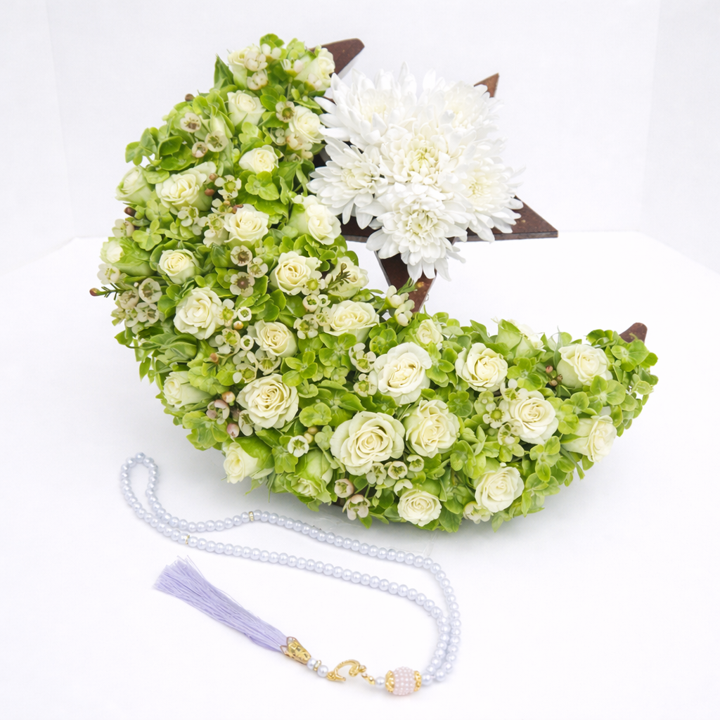 White and green floral crescent moon and star arrangement with white chrysanthemum, accompanied by lavender prayer beads with a purple tassel.