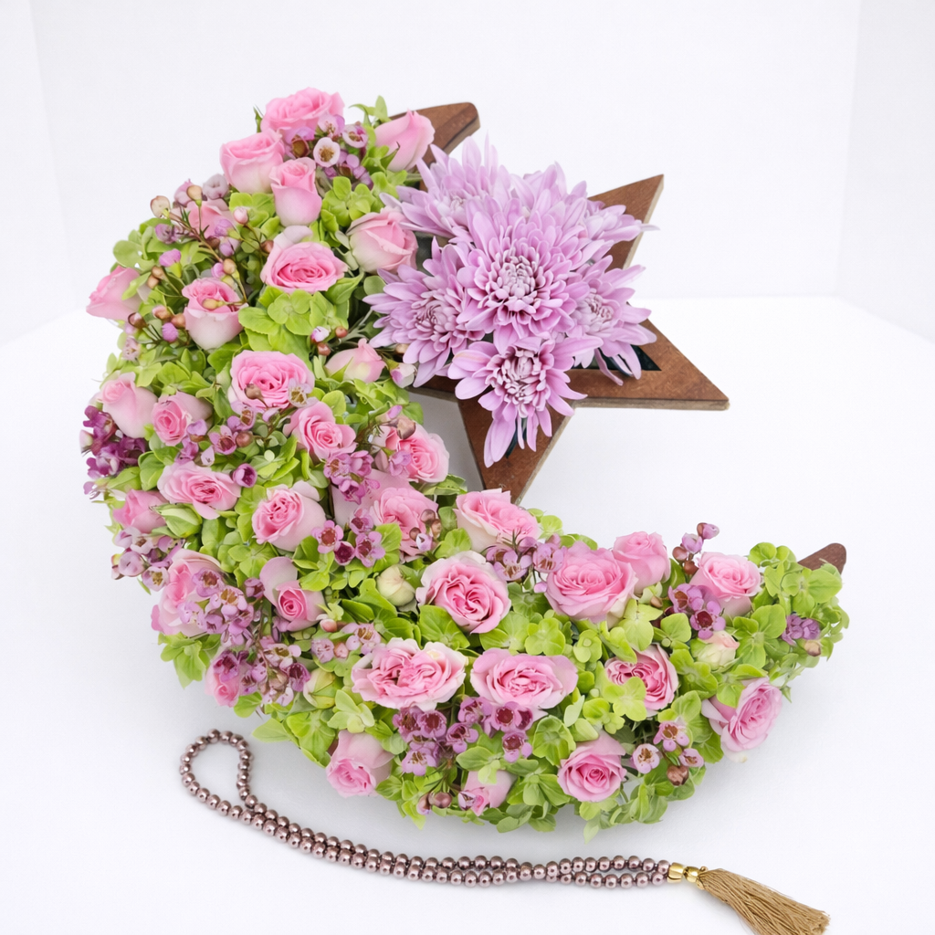 Pink floral crescent moon and star arrangement with prayer beads.