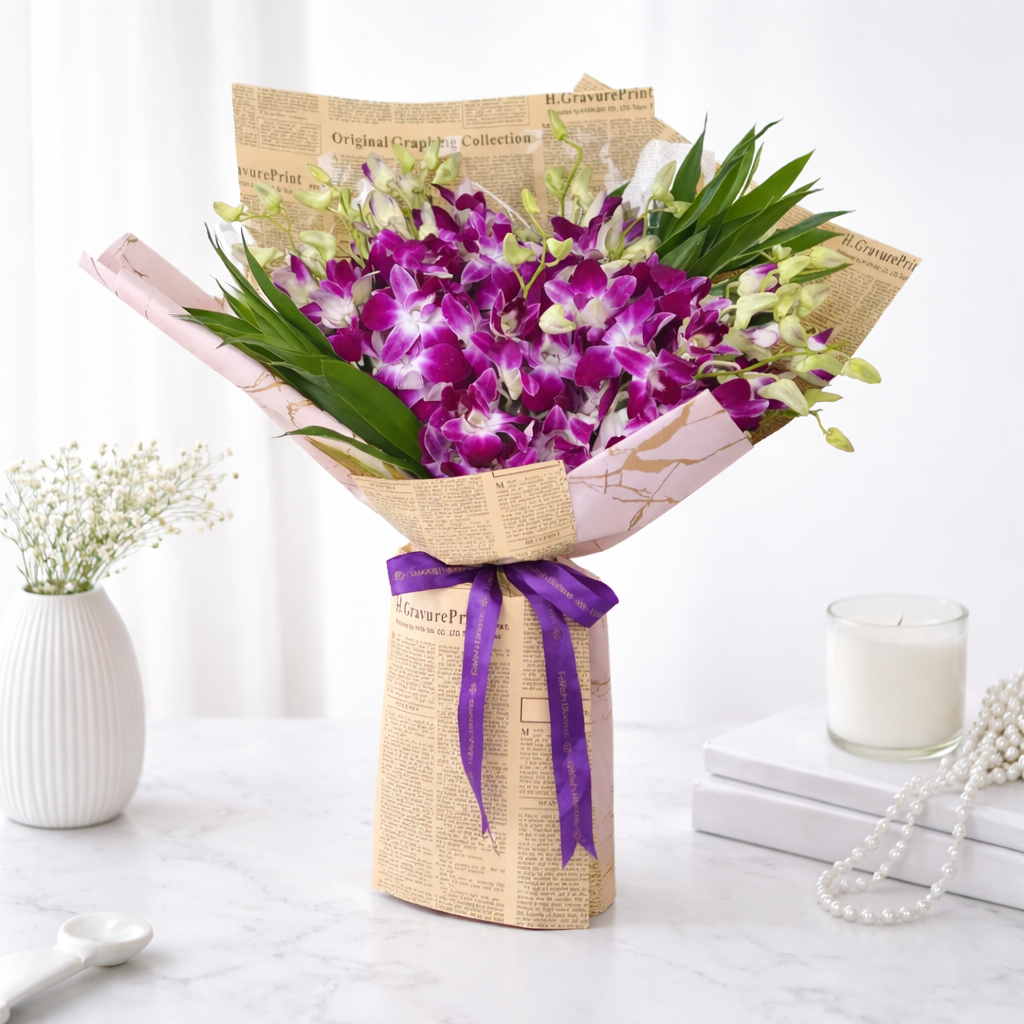 Purple orchid bouquet wrapped in newspaper print paper with a purple FaVish Blooms ribbon on a marble surface