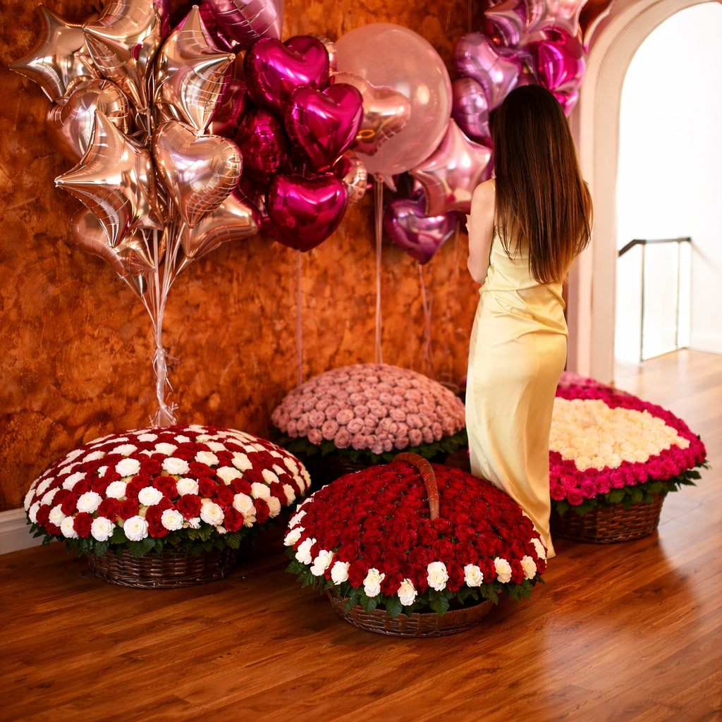 Woman in a yellow dress standing among large wicker baskets overflowing with roses and heart and star foil balloons.