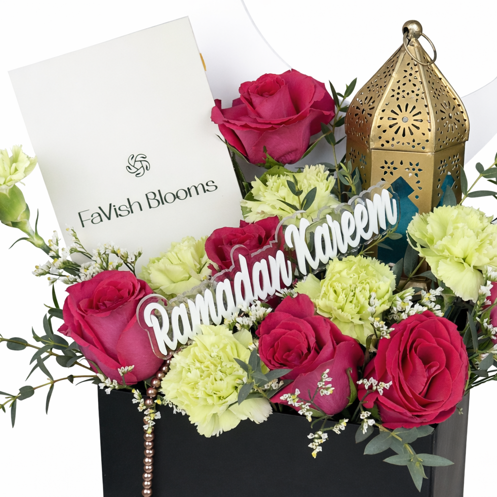 Close-up of Ramadan Kareem flower box with pink roses, carnations, gold lantern, and branded card.