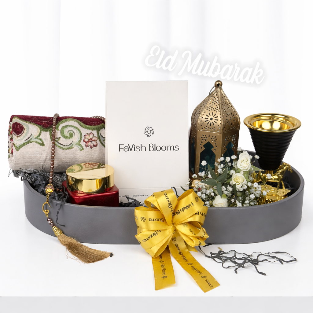 Eid Mubarak gift tray by FaVish Blooms with Moroccan lantern, oud burner, prayer mat, tasbih, and white flowers.