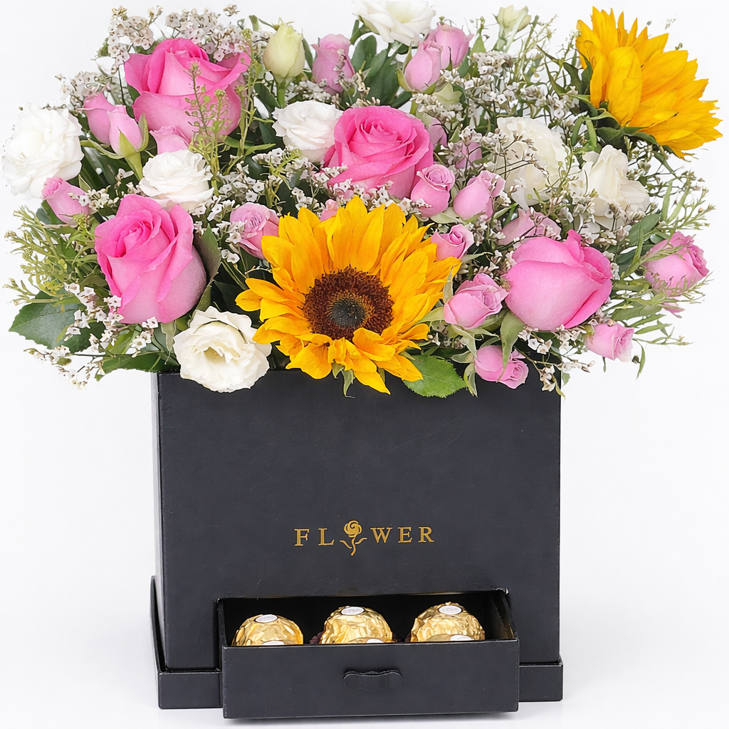 A branded black flower box with pink roses, sunflowers, and white lisianthus, with a slide-out drawer holding three Ferrero Rocher chocolates.