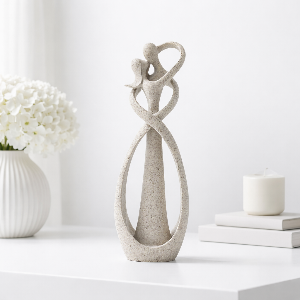 Abstract beige stone-finish sculpture of two intertwined figures embracing, forming a heart shape