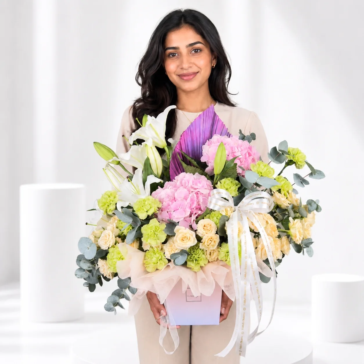 Woman holding pastel flower gift box by FaVish Blooms
