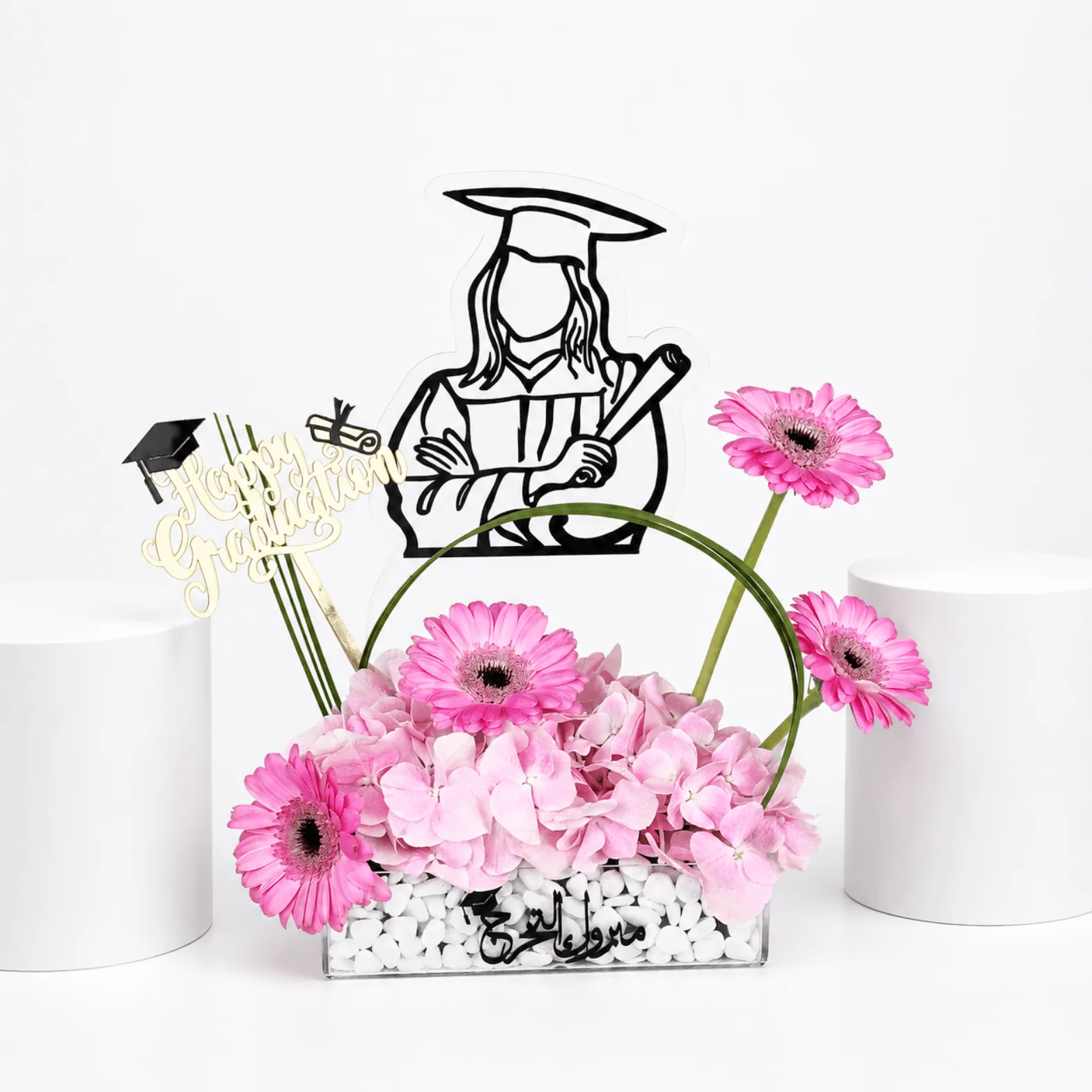 Pink graduation flower arrangement with graduate topper.